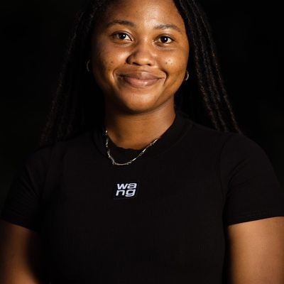 A portrait of a smiling woman in her 30s with a calm and welcoming expression.