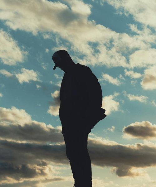 A silhouette of a person standing in a balanced, peaceful pose against a light background.